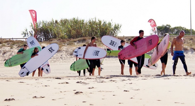 grupo de pequenos surfers llegando a la playa